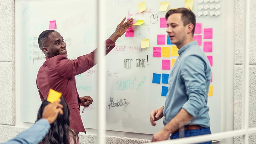 Coworkers sorting notes in office